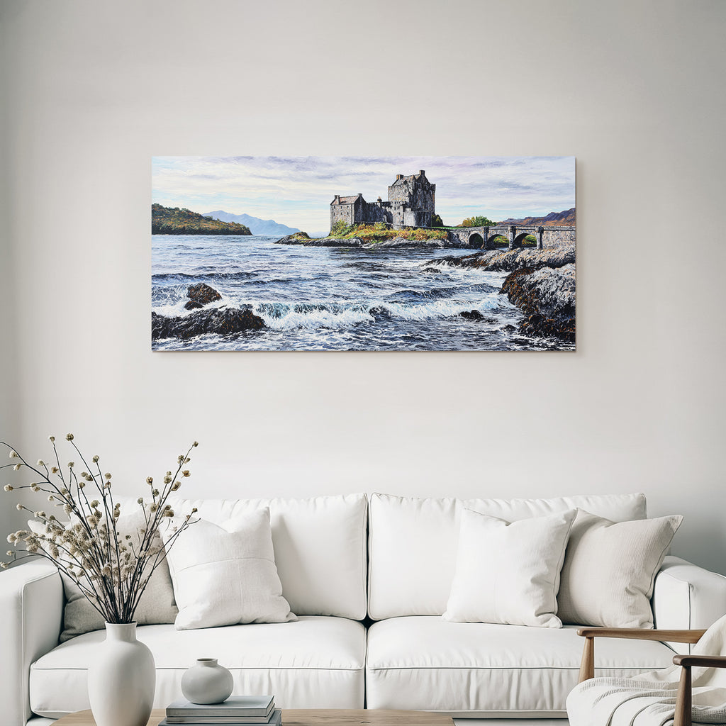 Castle on rock by the sea with bridge and mountains in the background