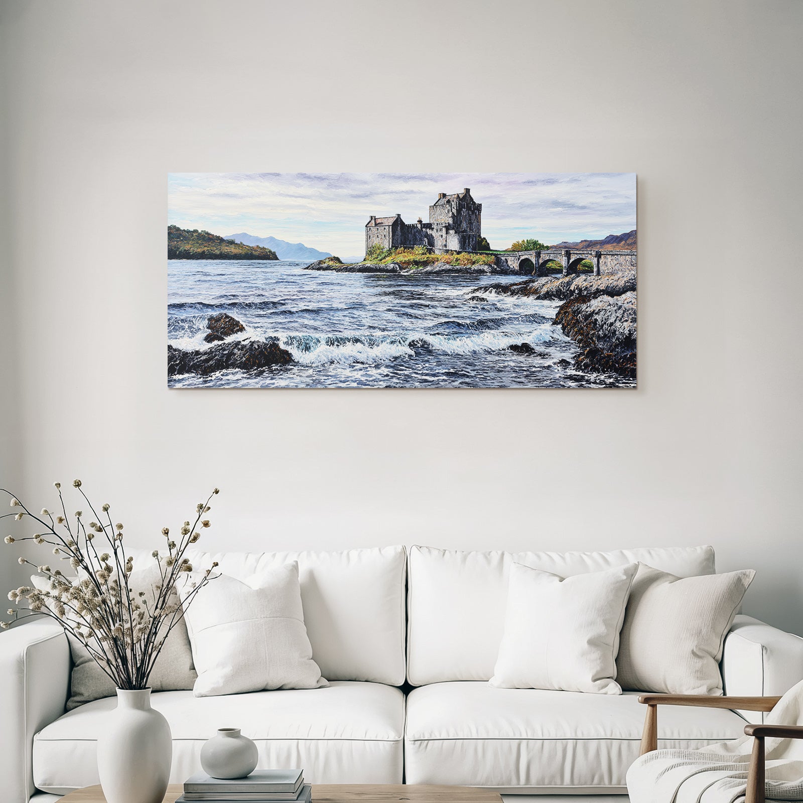 Castle on rock by the sea with bridge and mountains in the background