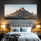 Medieval castle on a hill surrounded by greenery and village