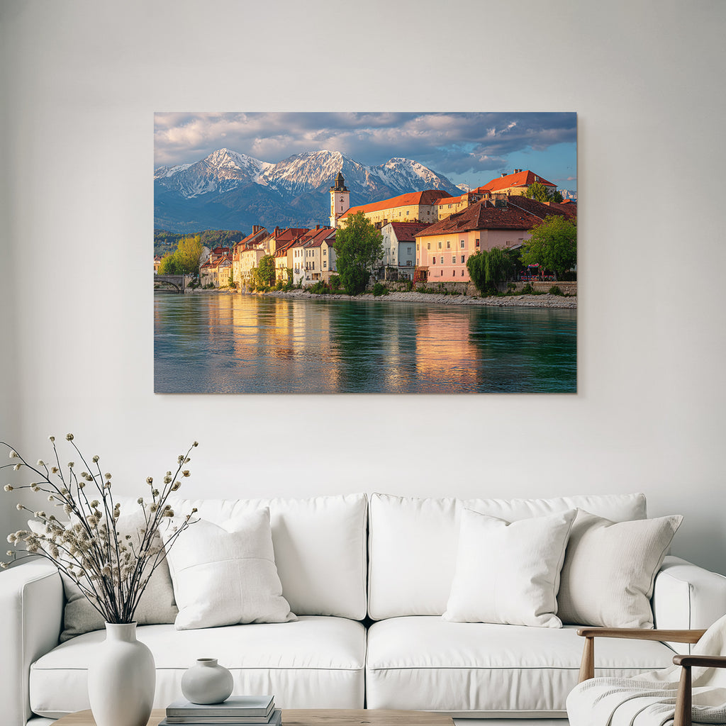 Scenic Riverside View With Red Tiled Roofs And Snow Capped Mountains