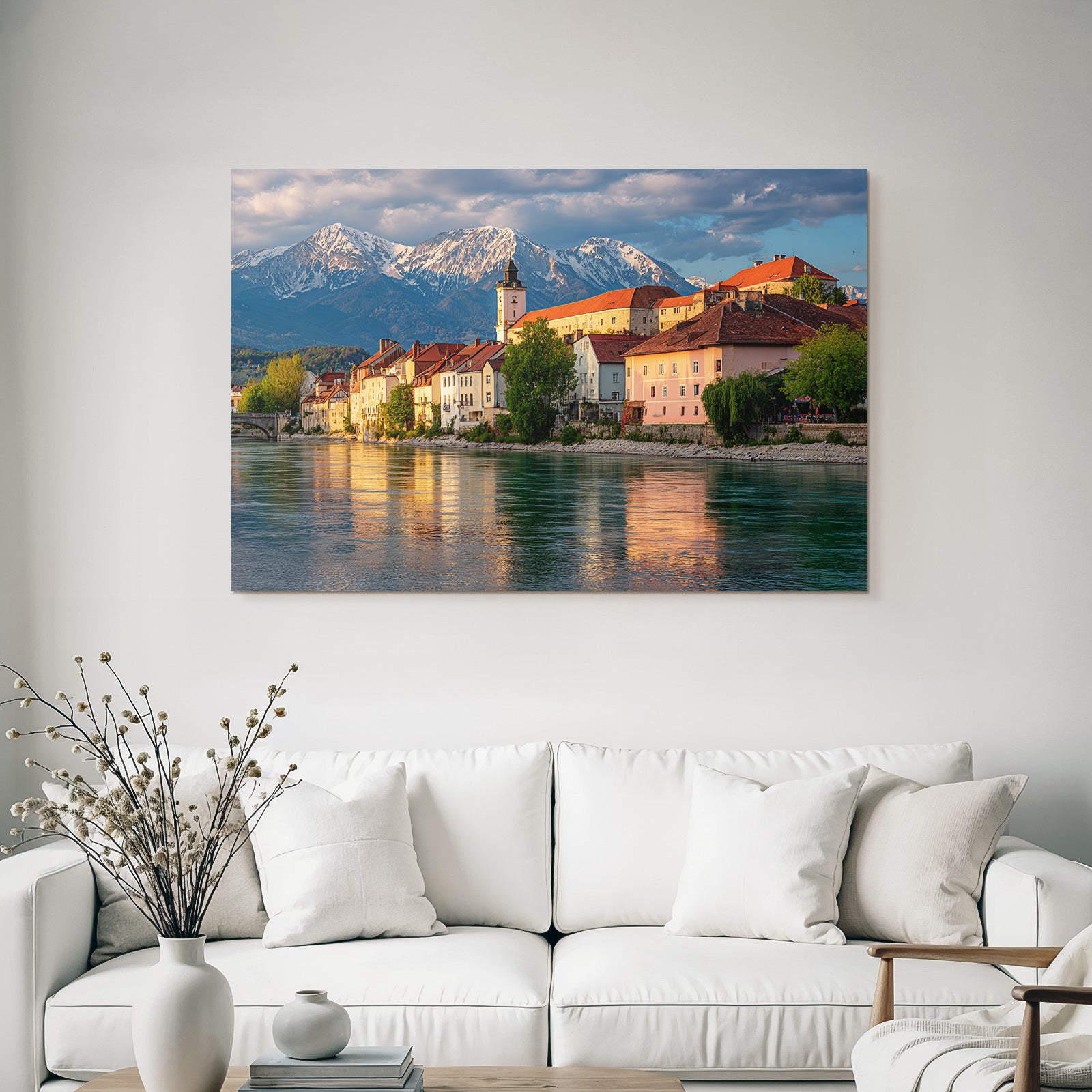 Scenic Riverside View With Red Tiled Roofs And Snow Capped Mountains