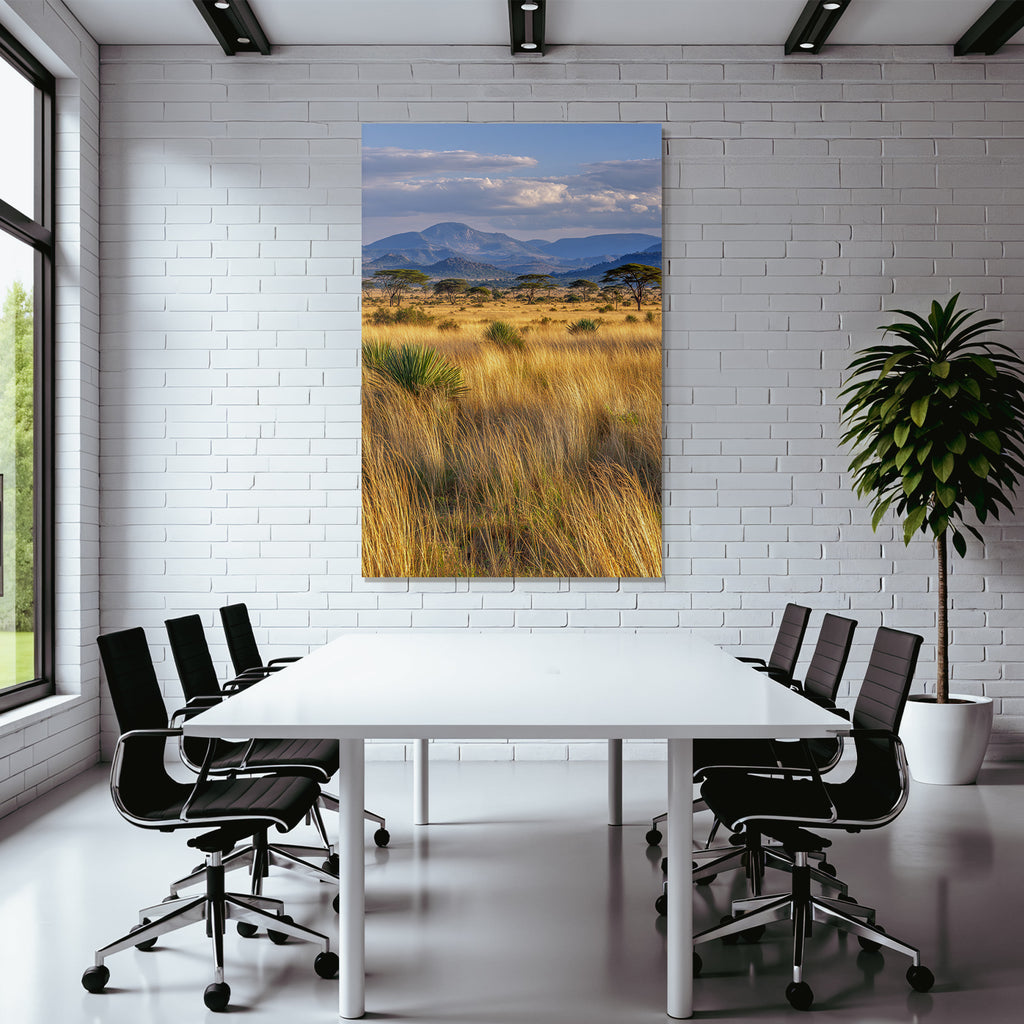Desert golden grassland with acacia trees and mountains under cloudy sky