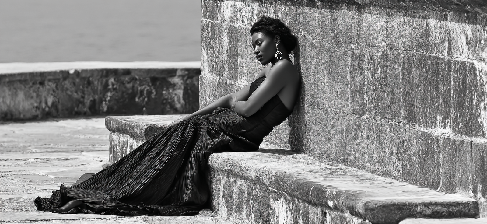 Dame In Elegantem Schwarzem Kleid Gedankenversunken An Einer Steinmaür | Portraets | Menschen und Emotionen
