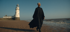 Person Am Strand Vor Leuchtturm In Eleganter Kleidung | Portraets | Menschen und Emotionen