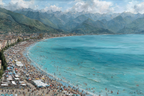 Strandlandschaft Mit Menschen Am Meer Mit Bergen Im Hintergrund | Humor und Schraeges | Themen und Hobbys