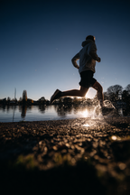 Laufender Sportler Im Sunset Am See Splashing Durch Wasser | Sport und Bewegung | Themen und Hobbys